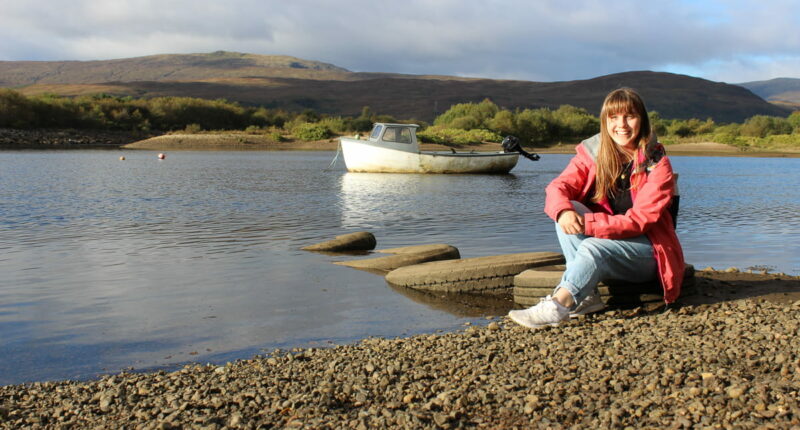 Melanie from the Absolute Escapes team sitting by River Lochy, Fort William (credit - Melanie Grandidge)