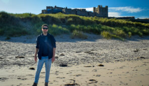 Northumberland Coast Path walker at Bamburgh Castle
