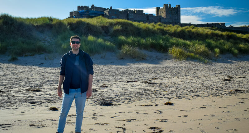 Northumberland Coast Path walker at Bamburgh Castle