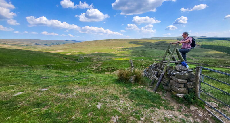 An Absolute Escapes client climbing over a stile on the Dales Way (credit - Marianne Engelshove)