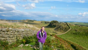 Daisy from the Absolute Escapes team in front of the view near Housesteads