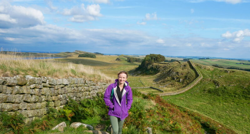 Daisy from the Absolute Escapes team in front of the view near Housesteads