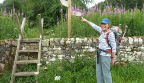 An Absolute Escapes client with a Hadrian's Wall Path waymarker (credit - Andrew Smith)