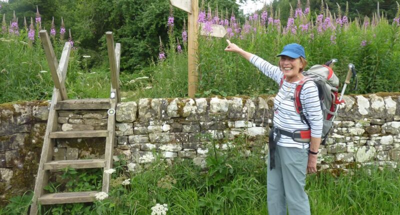 An Absolute Escapes client with a Hadrian's Wall Path waymarker (credit - Andrew Smith)