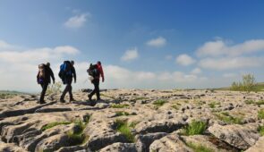 Walkers on the limestone pavement above the cliffs of Malham Cove