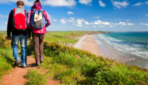 Couple walking on the trail with Newgale beach in distance