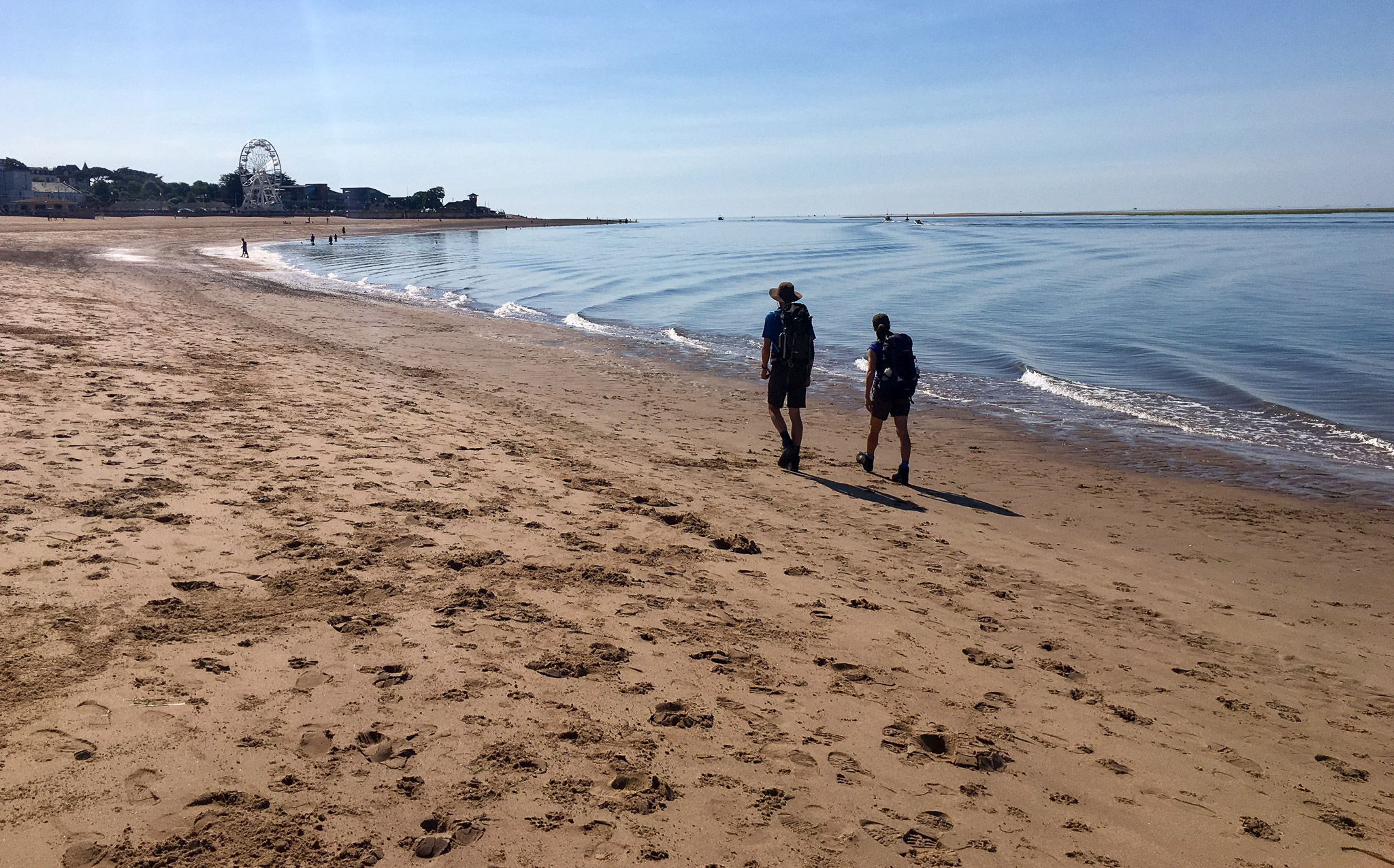 Hikers walking on the beach on the South West Coast Path