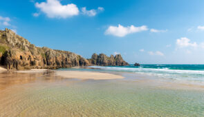 Turquoise shallow pools on Pednvounder Beach, looking towards Logan Rock, Cornwall