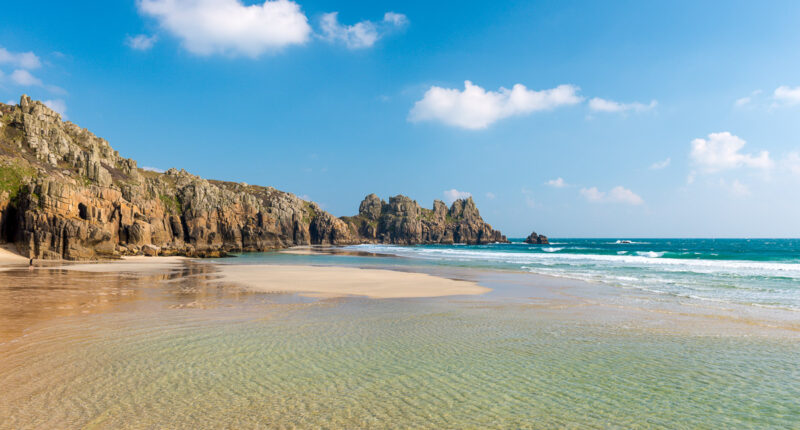 Turquoise shallow pools on Pednvounder Beach, looking towards Logan Rock, Cornwall