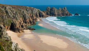 Pedn Vounder Beach, backed by the Logan Rock, Cornwall