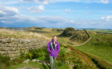 Daisy from the Absolute Escapes team in front of the view near Housesteads