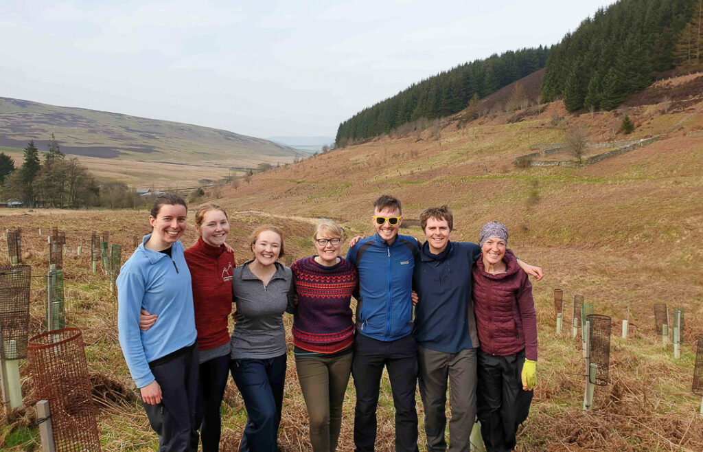 The Absolute Escapes team volunteering with the John Muir Trust and planting trees in the Scottish Borders