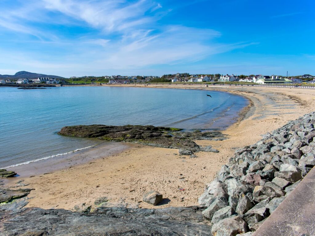Sandy beach and calm waters at Trearddur Bay, a relaxing stop along the Isle of Anglesey Coastal Path.