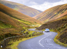 Car driving in scenic Scottish landscape