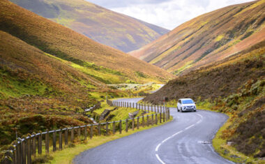 Car driving in scenic Scottish landscape