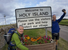 Hikers approaching Holy Island of Lindisfarne while walking St Cuthbert's Way