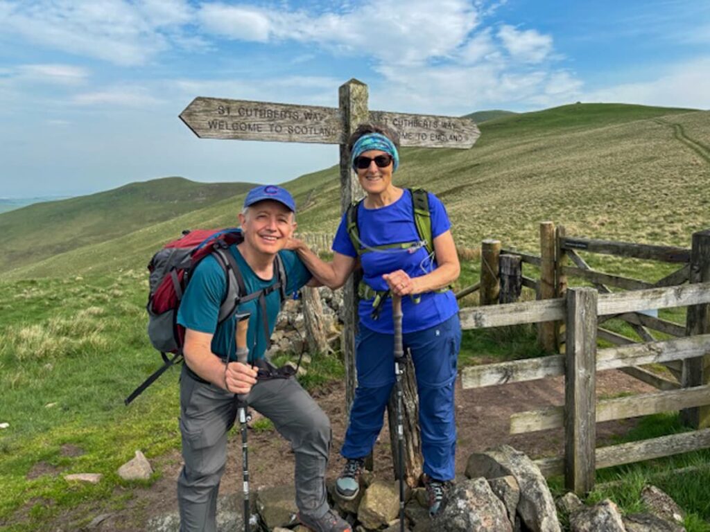 Walkers at the Scotland-England border marker along St Cuthbert's Way long distance trail