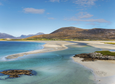 Luskentyre Beach under blue skies on Isle of Harris - pristine white sand and turquoise waters featured in road trip itineraries in Scotland's Outer Hebrides