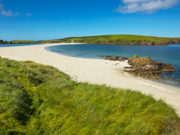 St Ninian's tombolo connecting mainland Shetland to St Ninian's Isle - dramatic coastal feature included in road trip itineraries in Scotland's remote islands