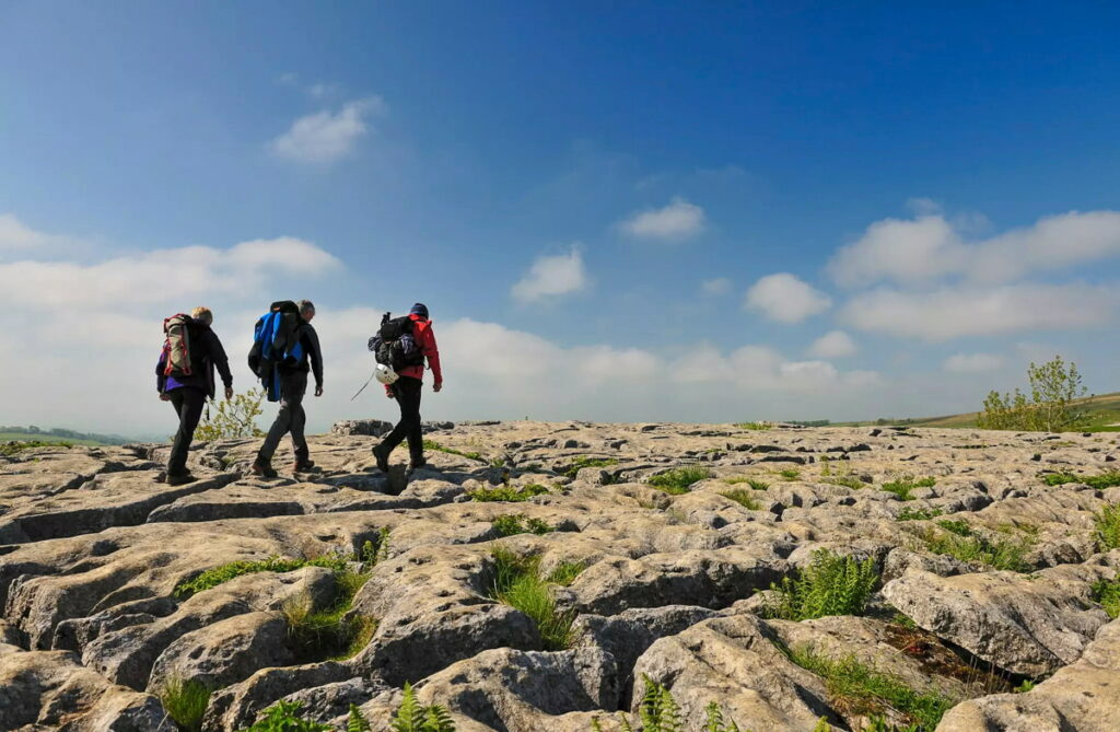 Walkers on the limestone pavement above Malham Cove on the Pennine Way