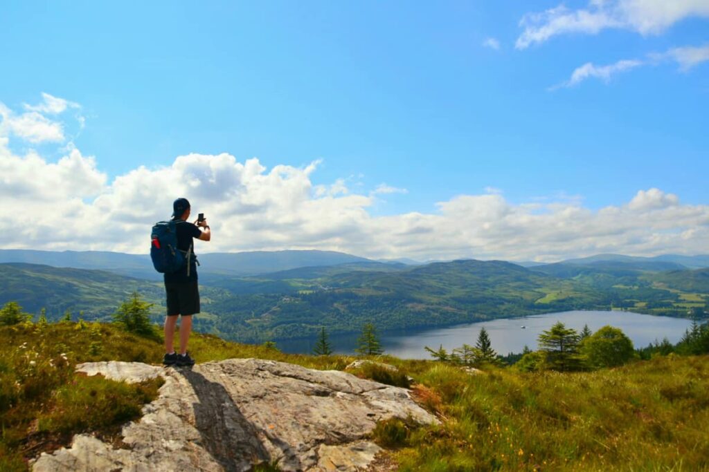 hiker enjoying panoramic mountain and loch views on the Great Glen Way walk through the Highlands
