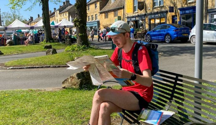 Hiker reading the Cotswold Round map