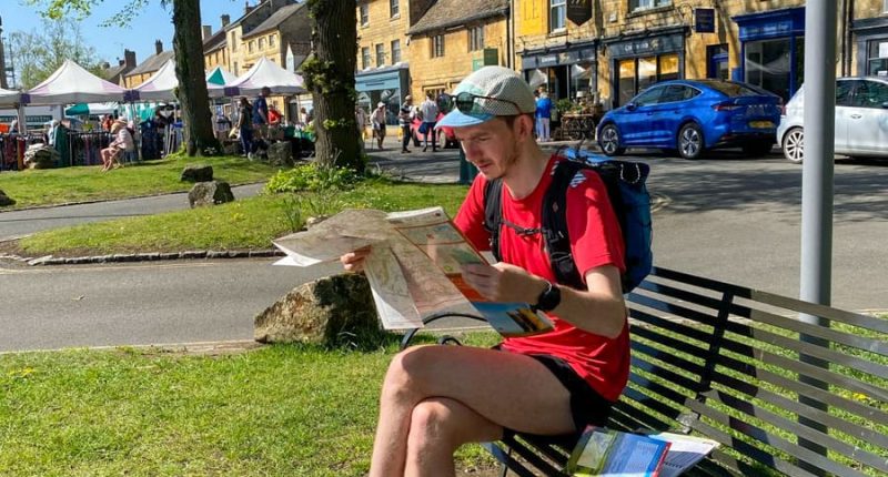 Hiker reading the Cotswold Round map