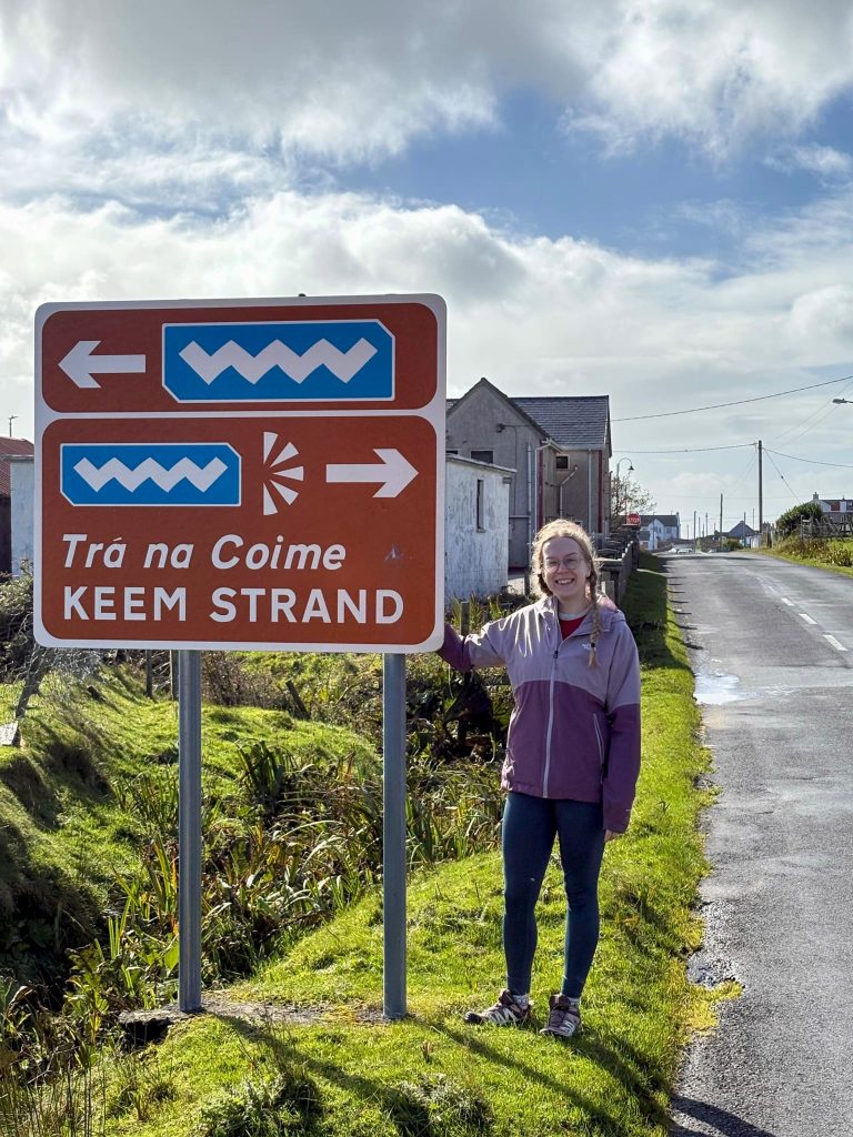 Our specialist, Ella, with one of the Wild Atlantic Way road signs