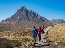 Hillwalkers on the West Highland Way passing Buachaille Etive Mor in Glencoe